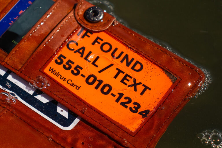 Orange Walrus Card in a brown leather wallet floating in the water